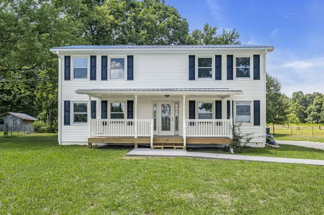 a large house with a big yard and large trees