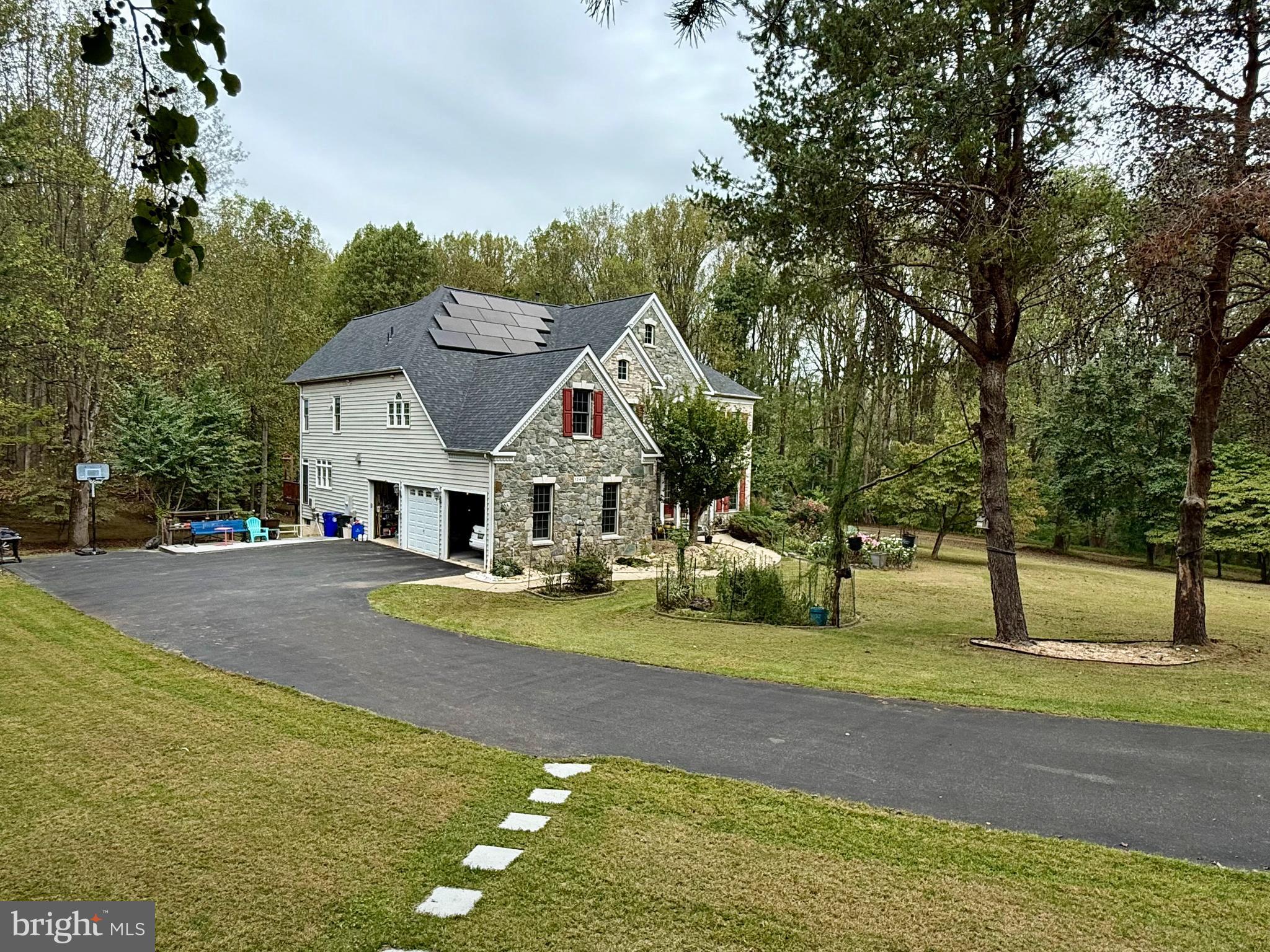 a view of a house with a big yard and large trees