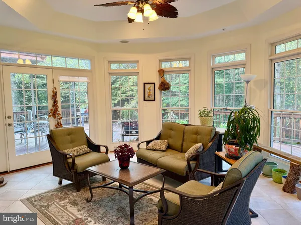 a living room with furniture a fireplace and a floor to ceiling window