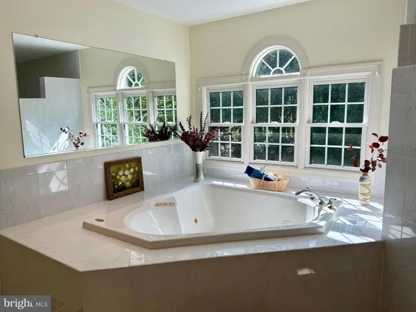 a spacious bedroom with a bed chair and window