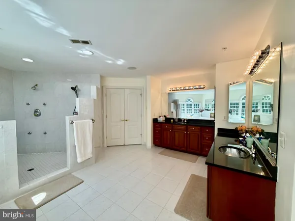 a bathroom with a sink a toilet a mirror and shower