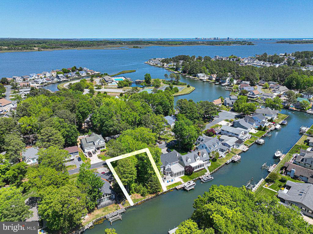 an aerial view of ocean and residential houses with outdoor space