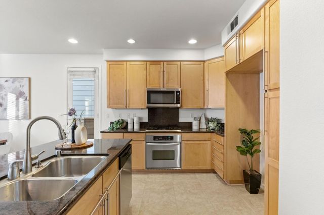 a kitchen with a sink a counter top space cabinets and stainless steel appliances