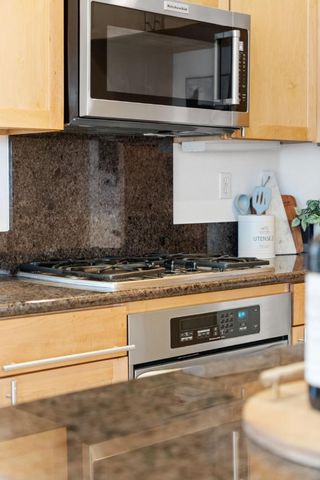 a kitchen with stainless steel appliances granite countertop a sink and a microwave