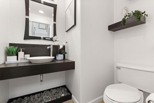 a bathroom with a sink a toilet and mirror