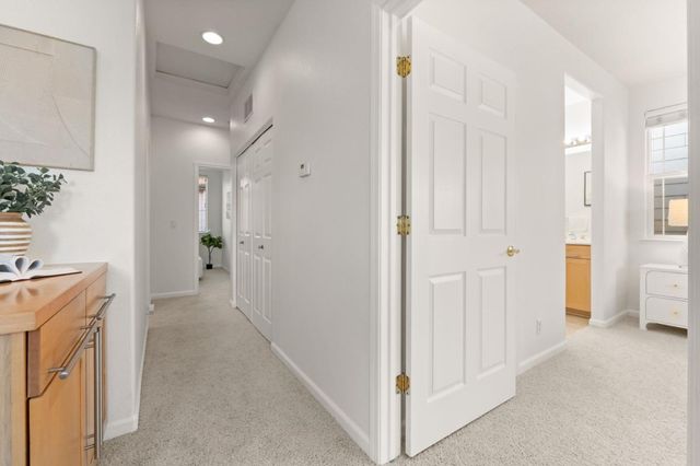 a view of a hallway with bathroom and wooden floor