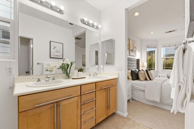 a spacious bathroom with a double vanity sink a mirror a bathtub and shower