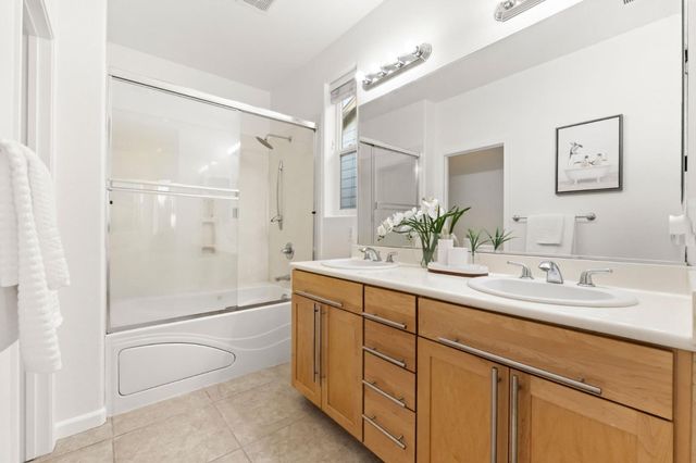 a bathroom with a double vanity sink toilet and shower