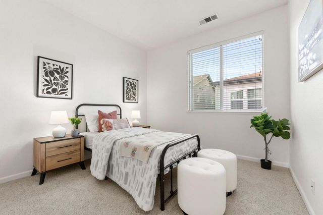 a bedroom with bed and a potted plant
