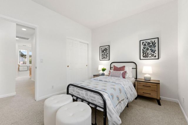 a bedroom with a bed and a lamp on dresser