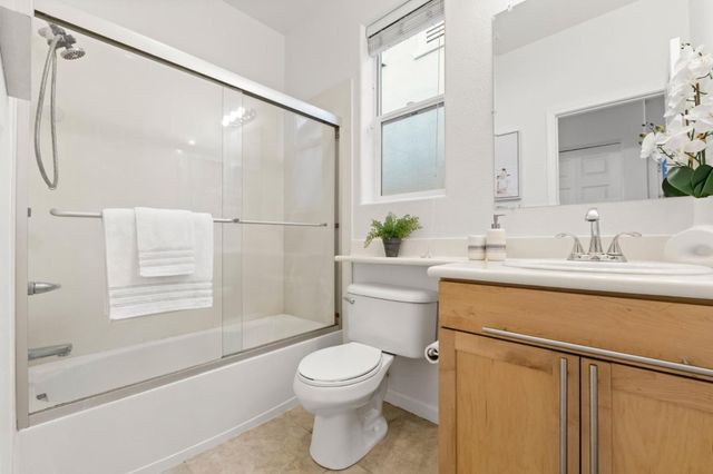 a bathroom with a sink a mirror toilet and shower
