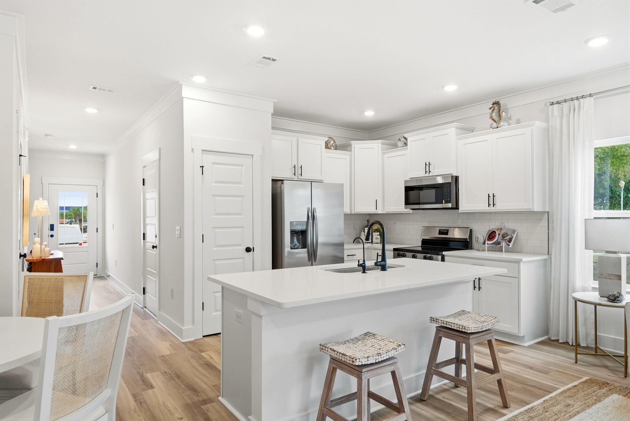 105 Foxtail Way, Unit 58 Destin, FL 32541 - Photo 10 of 21 a kitchen with stainless steel appliances a sink a stove a refrigerator cabinets and chairs