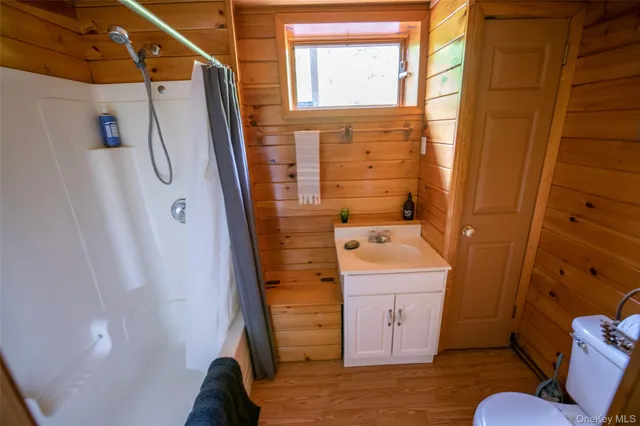 a kitchen with stainless steel appliances a stove a refrigerator a sink a dining table and chairs with wooden floor