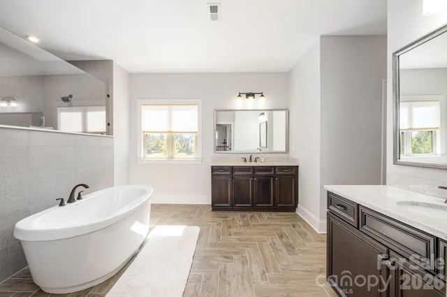 a large white tub sitting in a bathroom next to a window