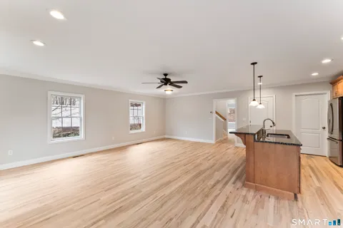 a view of a livingroom with wooden floor and kitchen