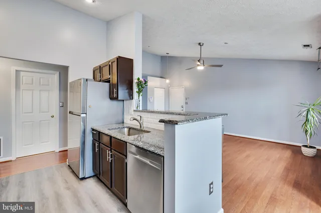 a kitchen with a sink cabinets and wooden floor