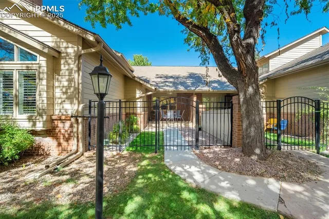 a view of a house with a large tree and wooden fence