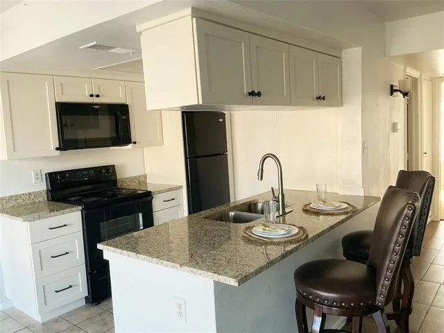 a kitchen with a sink microwave and cabinets