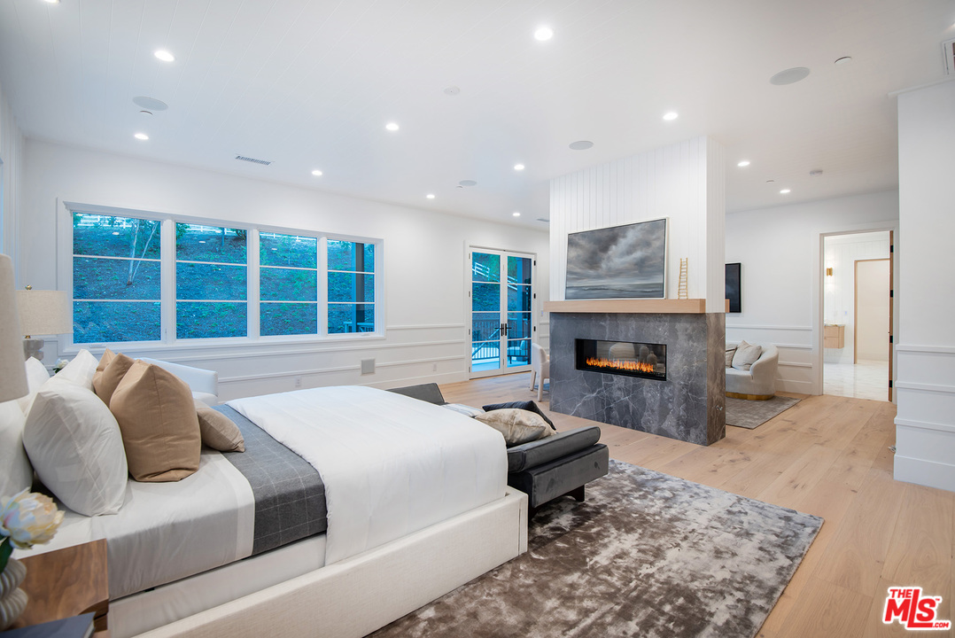 5716 Jed Smith Road Hidden Hills, CA 91302 - Photo 36 of 53 a bed room with a bed and a fireplace