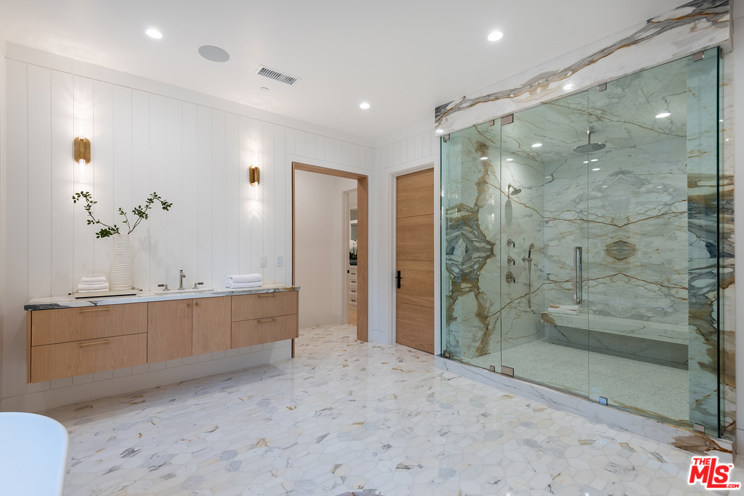 5716 Jed Smith Road Hidden Hills, CA 91302 - Photo 39 of 53 a bathroom with a mirror a double vanity sink and shower