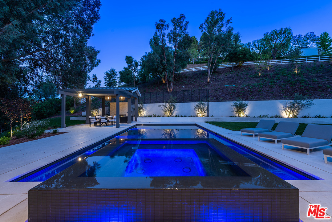 5716 Jed Smith Road Hidden Hills, CA 91302 - Photo 47 of 53 a view of swimming pool with seating area and trees in the background
