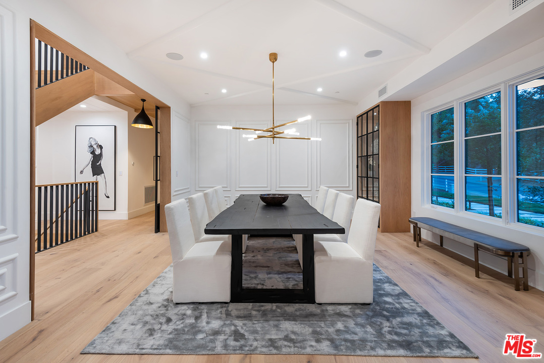 5716 Jed Smith Road Hidden Hills, CA 91302 - Photo 7 of 53 a dining room with wooden floor a chandelier a wooden table and chairs