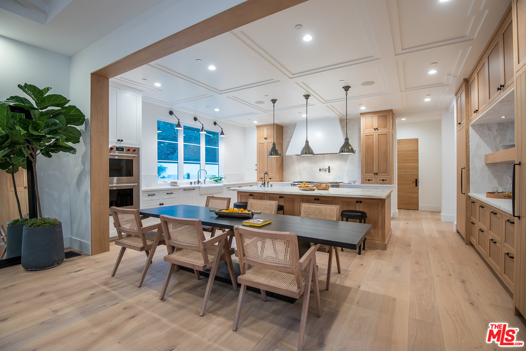 5716 Jed Smith Road Hidden Hills, CA 91302 - Photo 9 of 53 a kitchen with stainless steel appliances kitchen island granite countertop a table chairs sink and cabinets