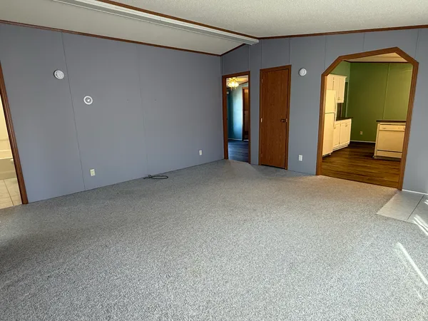 a view of an empty room with glass door and a window