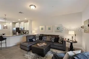 a living room with furniture and a view of kitchen