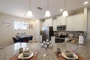 8653 Karpeal Drive, Unit 4 Sarasota, FL 34238 - Photo 4 of 14 a kitchen with sink refrigerator and microwave