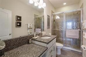 8653 Karpeal Drive, Unit 4 Sarasota, FL 34238 - Photo 7 of 14 a bathroom with a granite countertop sink toilet and shower