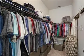 a view of walk in closet with clothes and shoes