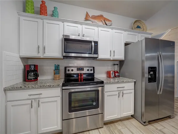 a kitchen with stainless steel appliances granite countertop a refrigerator stove and sink