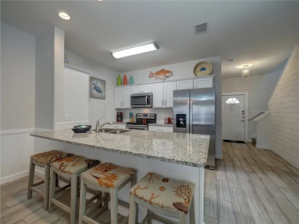 a kitchen with stainless steel appliances granite countertop a sink counter space and wooden floor