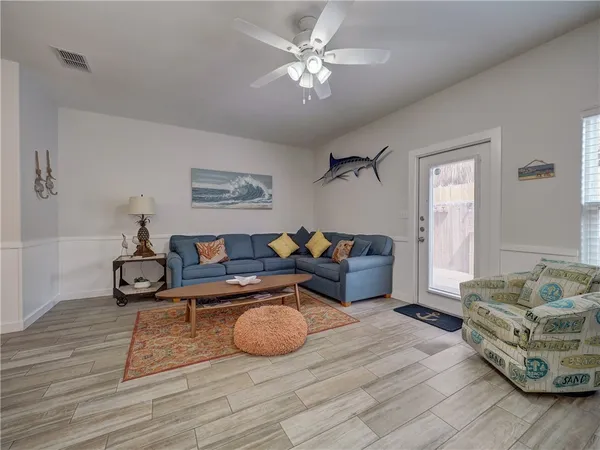 a living room with furniture and a wooden floor