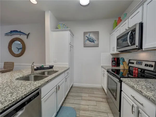 a kitchen with stainless steel appliances granite countertop a sink and a stove