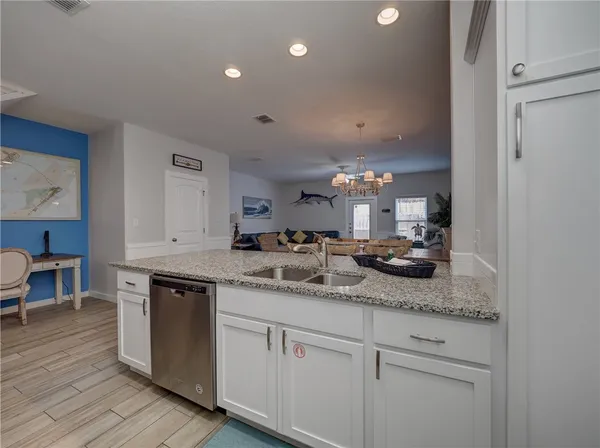 a kitchen with a sink double cabinets and wooden floor