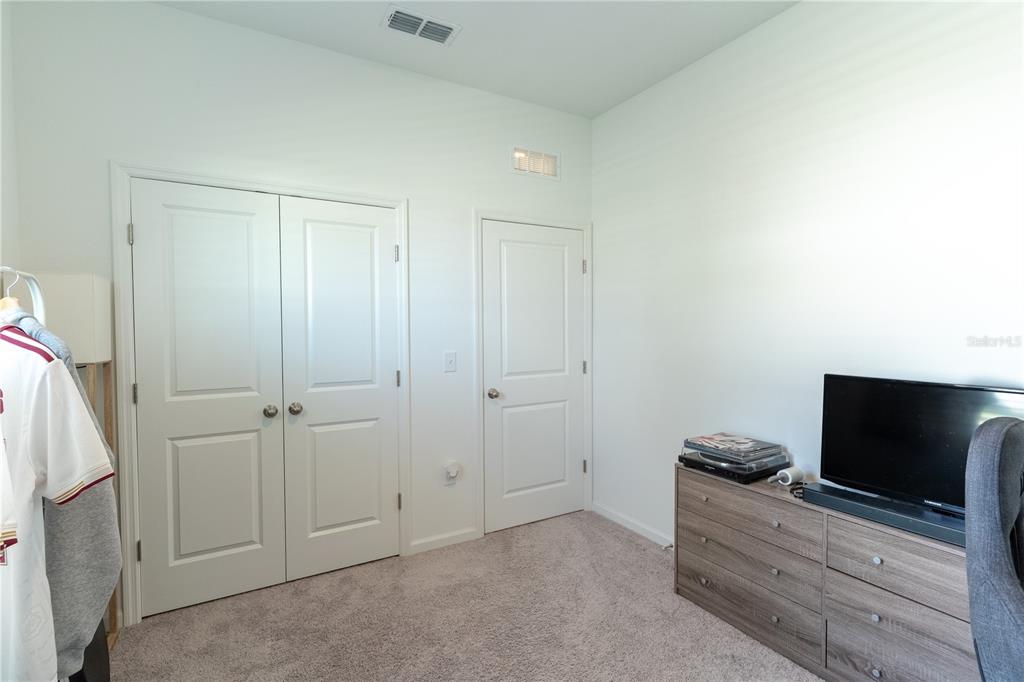 2248 Crossbow Street Minneola, FL 34715 - Photo 19 of 33 a bedroom with a bed and a flat screen tv