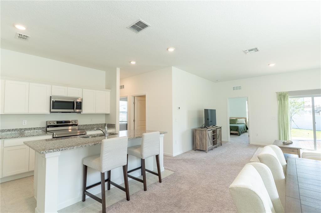 2248 Crossbow Street Minneola, FL 34715 - Photo 8 of 33 a kitchen that has a lot of cabinets a sink and a stove in it
