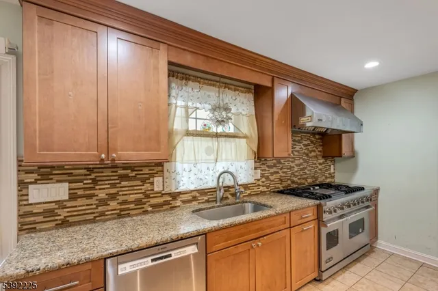 a kitchen with stainless steel appliances granite countertop a sink a stove and a microwave