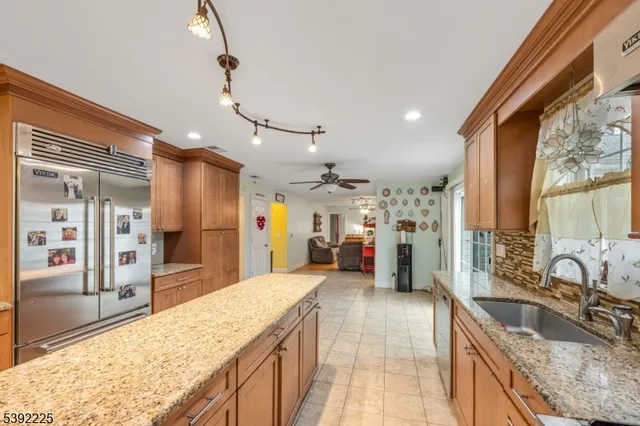 a large kitchen with kitchen island granite countertop a large counter top stainless steel appliances and cabinets