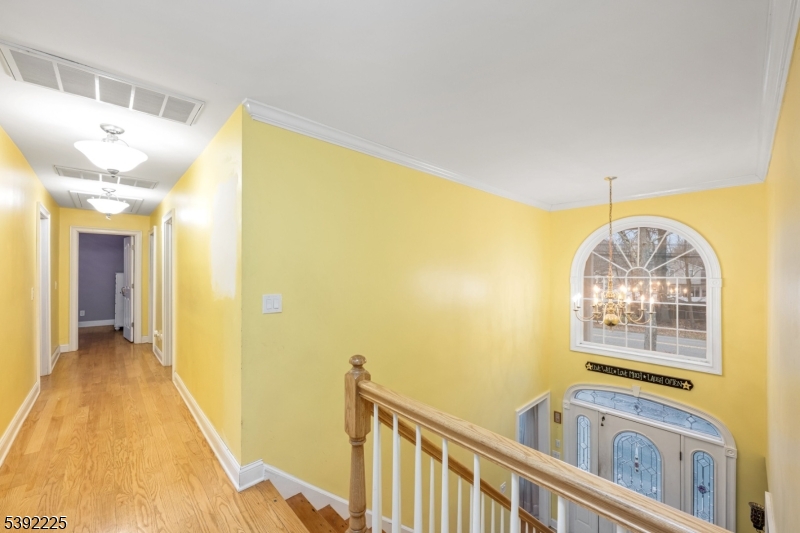 255 Knoll Road Lake Hiawatha, NJ 07034 - Photo 19 of 32 a view of a hallway with wooden floor and chandelier