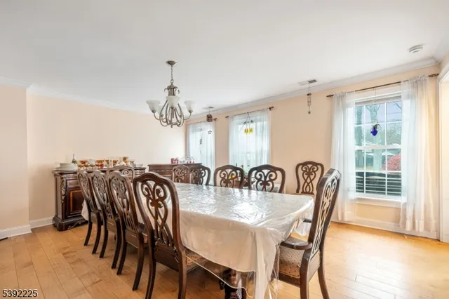 a view of a a dining room with furniture window and wooden floor