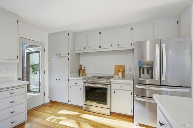 a large white kitchen with a large window