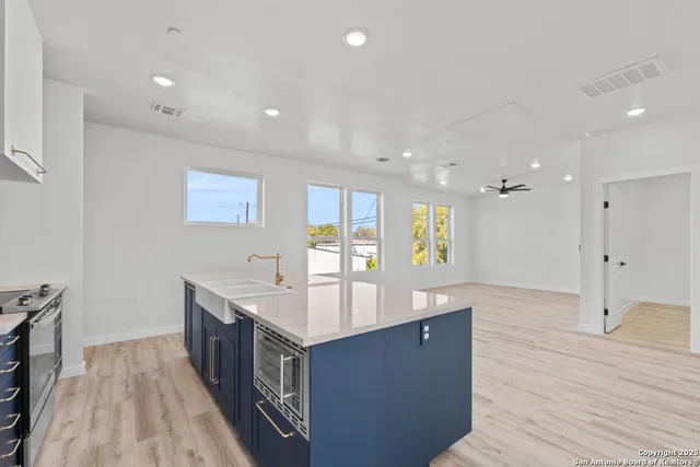 a large kitchen with stainless steel appliances a large counter top and a wooden floors