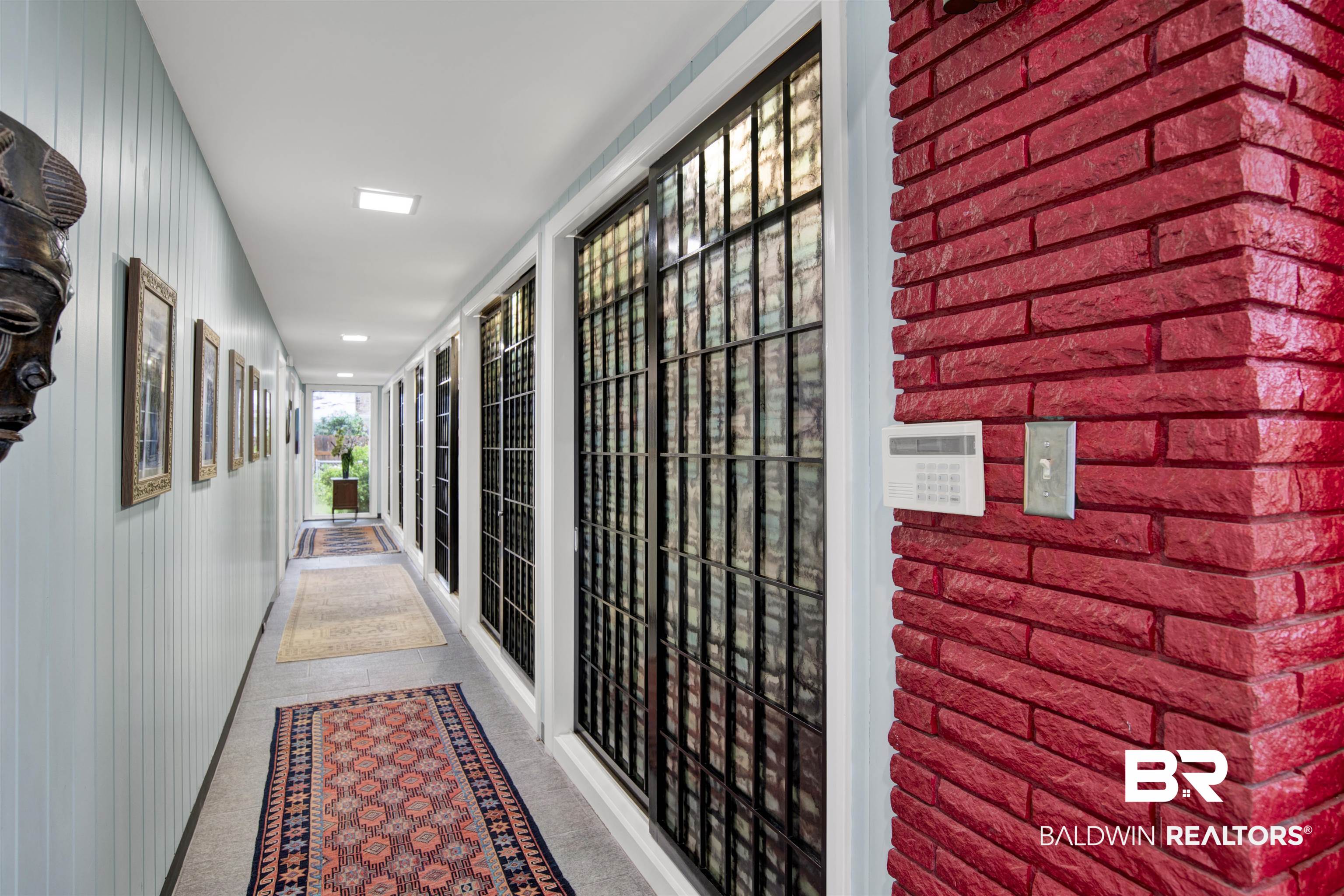 809 Bernard Circle Mobile, AL 36693 - Photo 19 of 75 Corridor with light blue vertical paneling, recessed lighting, and a red brick wall accent