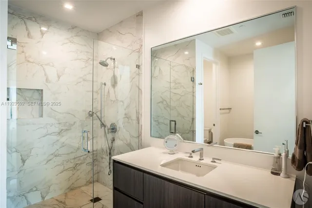 a bathroom with a sink shower and a mirror
