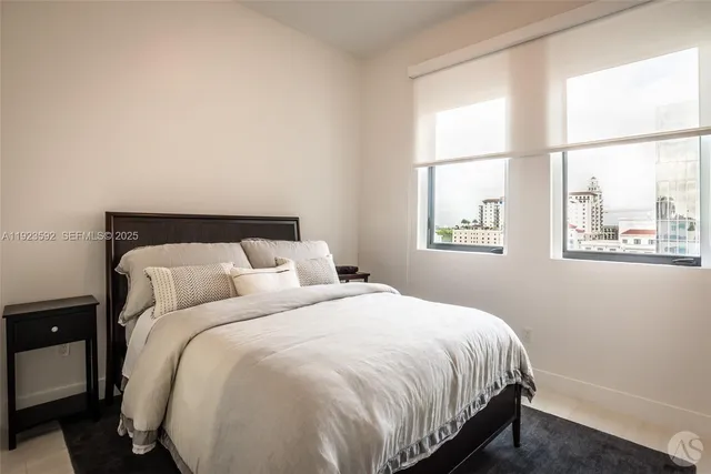a large bed sitting in a bedroom next to a window
