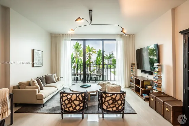 a living room with furniture a flat screen tv and a large window