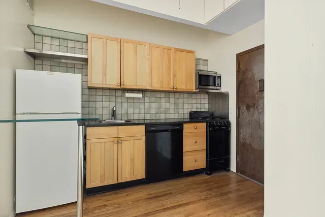 a kitchen with stainless steel appliances granite countertop a refrigerator and a stove top oven